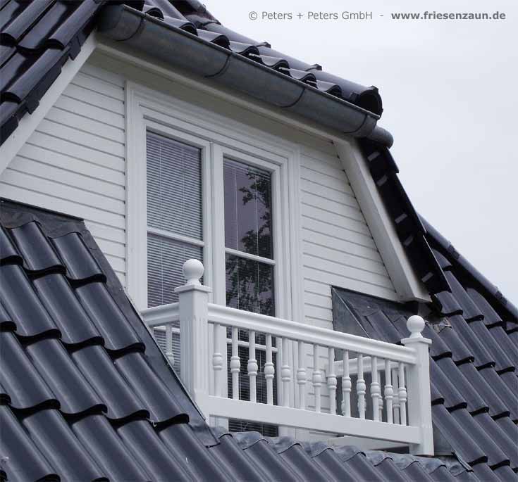 Weißes Balkongeländer Holz mit gedrechselten Stäben.