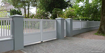 Hohes Gartentor - extra massives Holztor mit massivem Holzzaun auf Mauersockel.