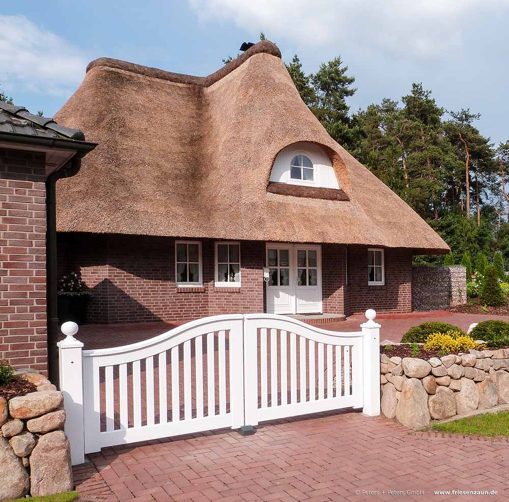 Friesentor SCHLESWIG vor einer reetgedeckten Villa - Gartengestaltung mit Friesenwall.