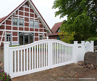 Die weißen Gartentore von Peters + Peters passen zu vielen Haustypen - hiert ein Gartentor Schleswig vor einem klassischem Fachwerkhaus.